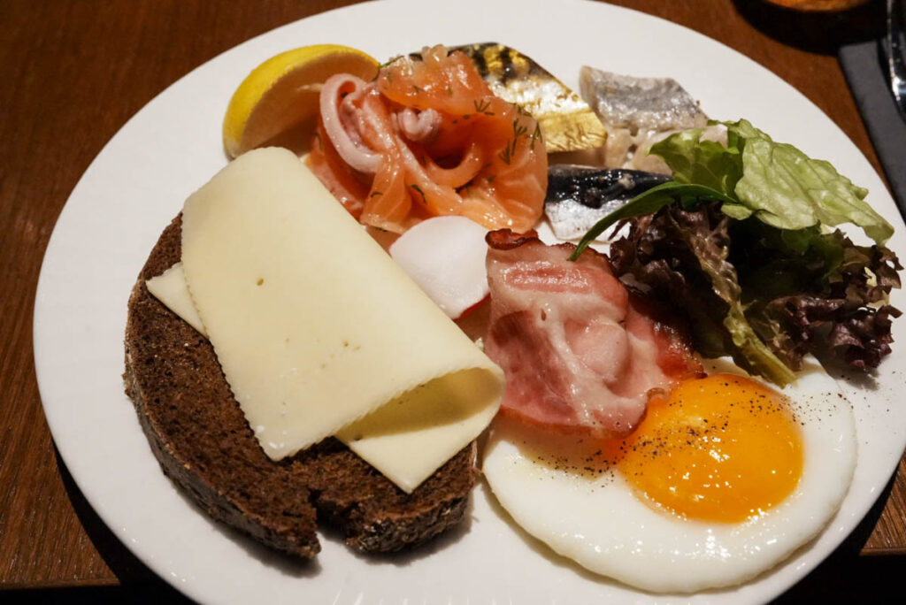 首都リーガで泊まったホテル「Grand Poet」の朝食。薄い黒パンにチーズをのせてⒸPen＆Voyage