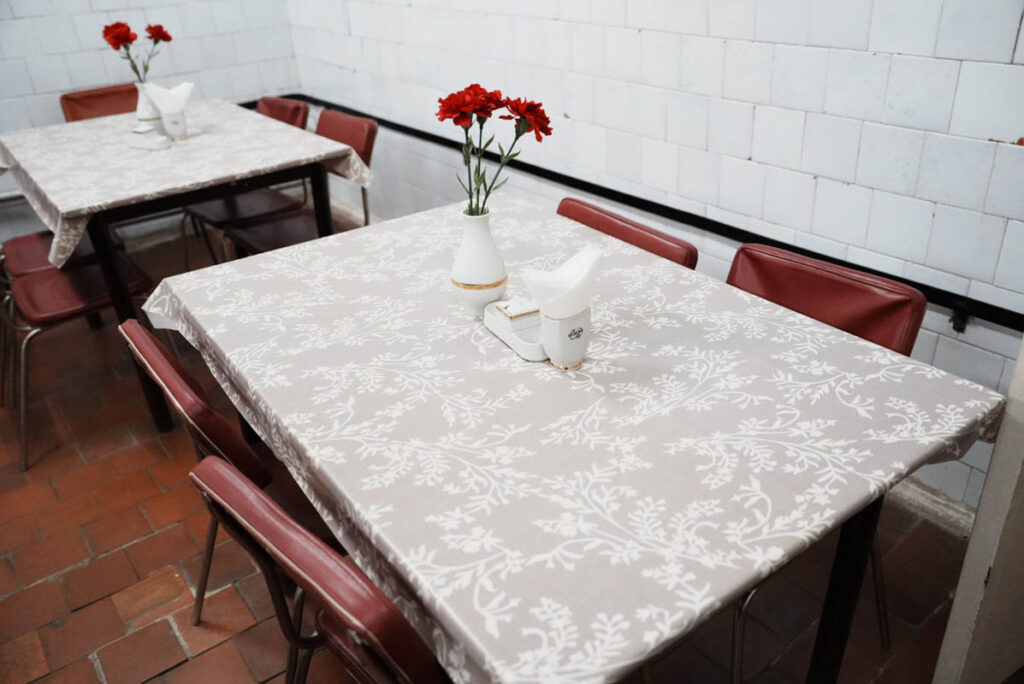 白いビニールのテーブルクロスに赤いカーネーションの食卓ⒸPen&Voyage