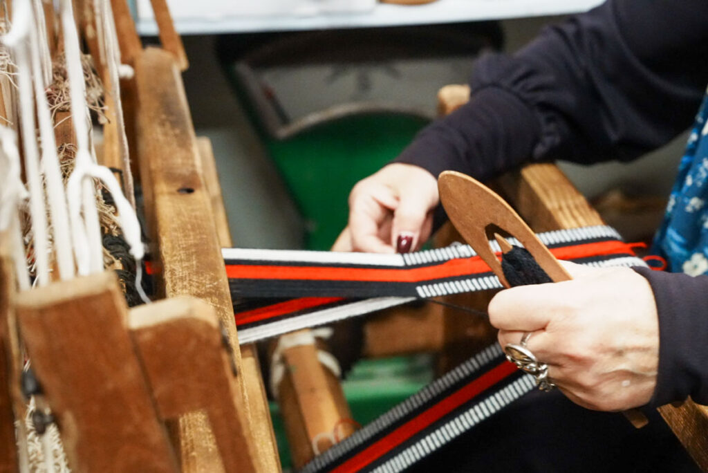 経糸にシャトルを差し込んで織るⒸPen&Voyage