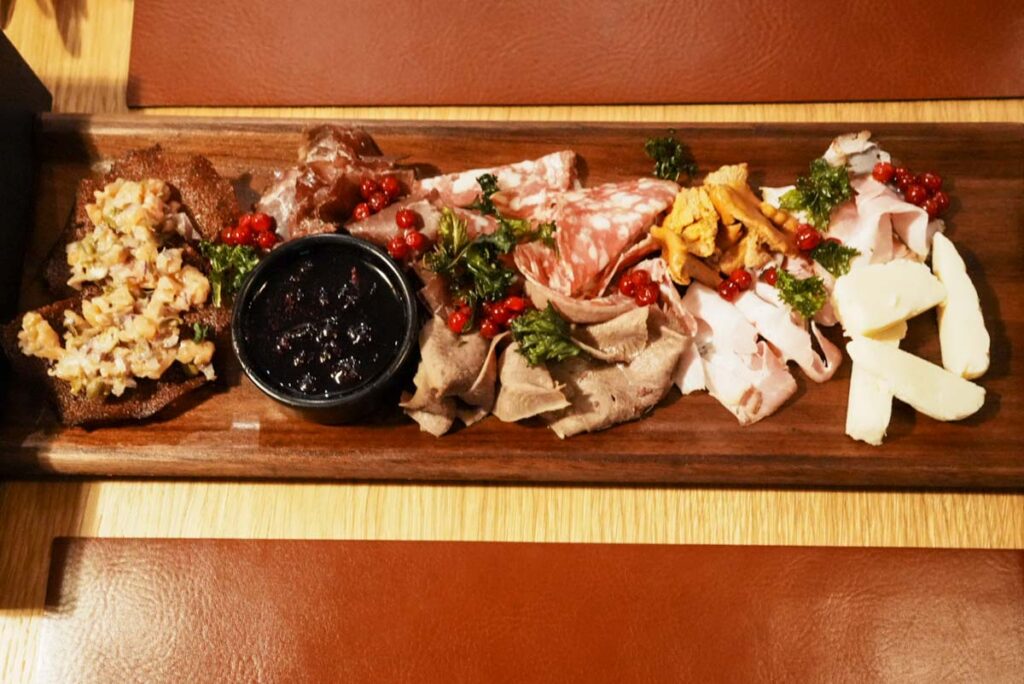 前菜のプレート。冷燻の鹿肉、温燻の豚バラ肉、スモークした鹿の心臓、ラムのサラミ、北極トラウト、カシスとローズマリーのソース、自家製フレッシュチーズ、アンズタケ(ジロール茸)ⒸPen&Voyage