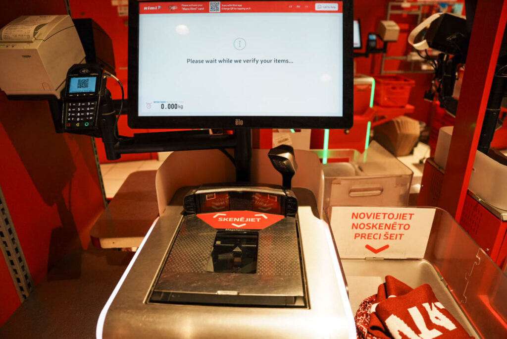 ラトビアのスーパーRimiのセルフレジ。赤いシールの貼られた部分に商品のバーコードをかざす。スキャンした商品は右に置くⒸPen＆Voyage