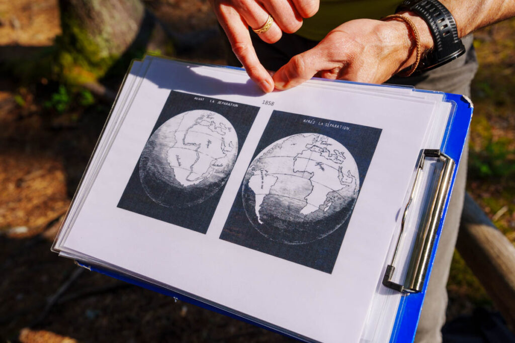 「分裂前」と「分裂後」の大陸図を手に、当時の地球の様子を解説してくれるローランドさん ⒸPen＆Voyage